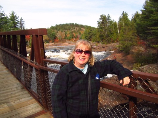 Blonde woman at the bridge over Onaping River and Falls